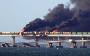 Black smoke billows from a fire on the Kerch bridge that links Crimea to Russia, after a truck exploded, near Kerch, on October 8, 2022. - Moscow announced on October 8, 2022 that a truck exploded igniting a huge fire and damaging the key Kerch bridge -- built as Russia's sole land link with annexed Crimea -- and vowed to find the perpetrators, without immediately blaming Ukraine. (Photo by AFP)