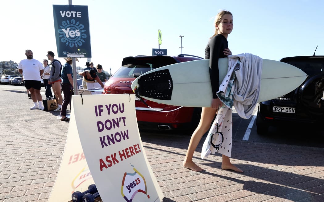 A surfer walks towards a polling station on Bondi Beach in Sydney on October 14, 2023, as polls open in Australia's historic Indigenous rights referendum. (Photo by DAVID GRAY / AFP)