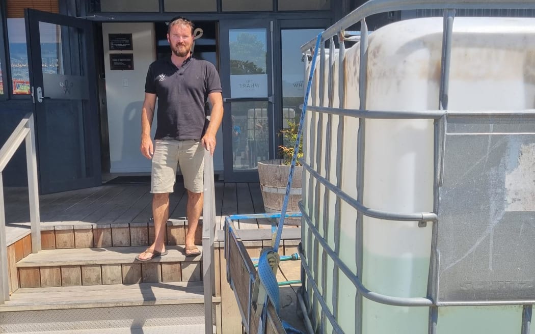 Restaurant Wharf owner and manager Grant Fussell drove a trailer to work with a 1000-litre drum of his home tank water.