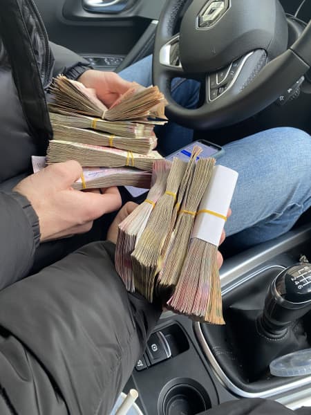 Lisa Reymer holding wads of cash.