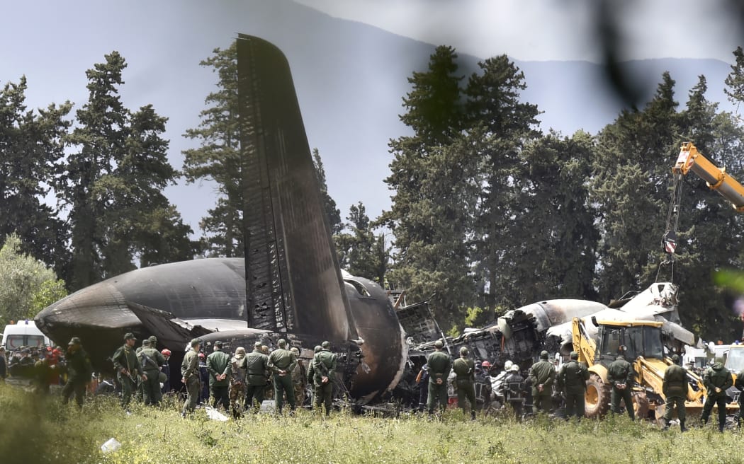 Rescuers gather around the wreckage of an Algerian army plane which crashed near the Boufarik airbase from where the plane had taken off on April 11, 2018.