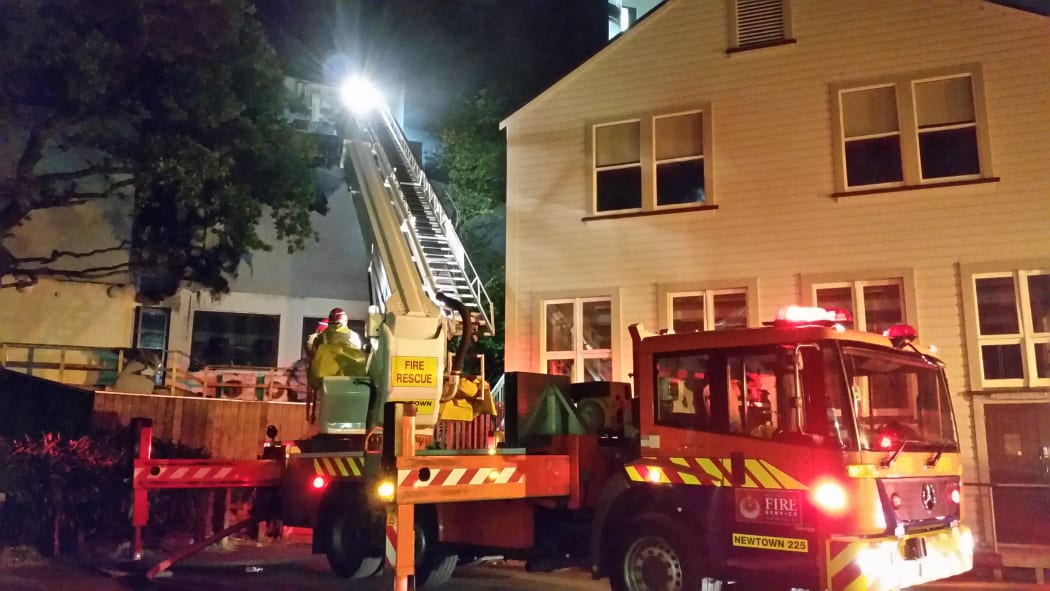 Fire fighters check the ceiling cavities for spread of the fire.