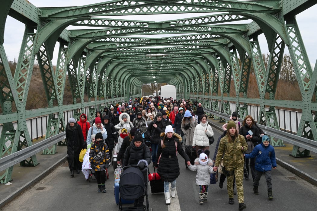 Ukrainian refugees walk a bridge at the buffer zone with the border with Poland in the border crossing of Zosin-Ustyluh, western Ukraine on 6 March, 2022.