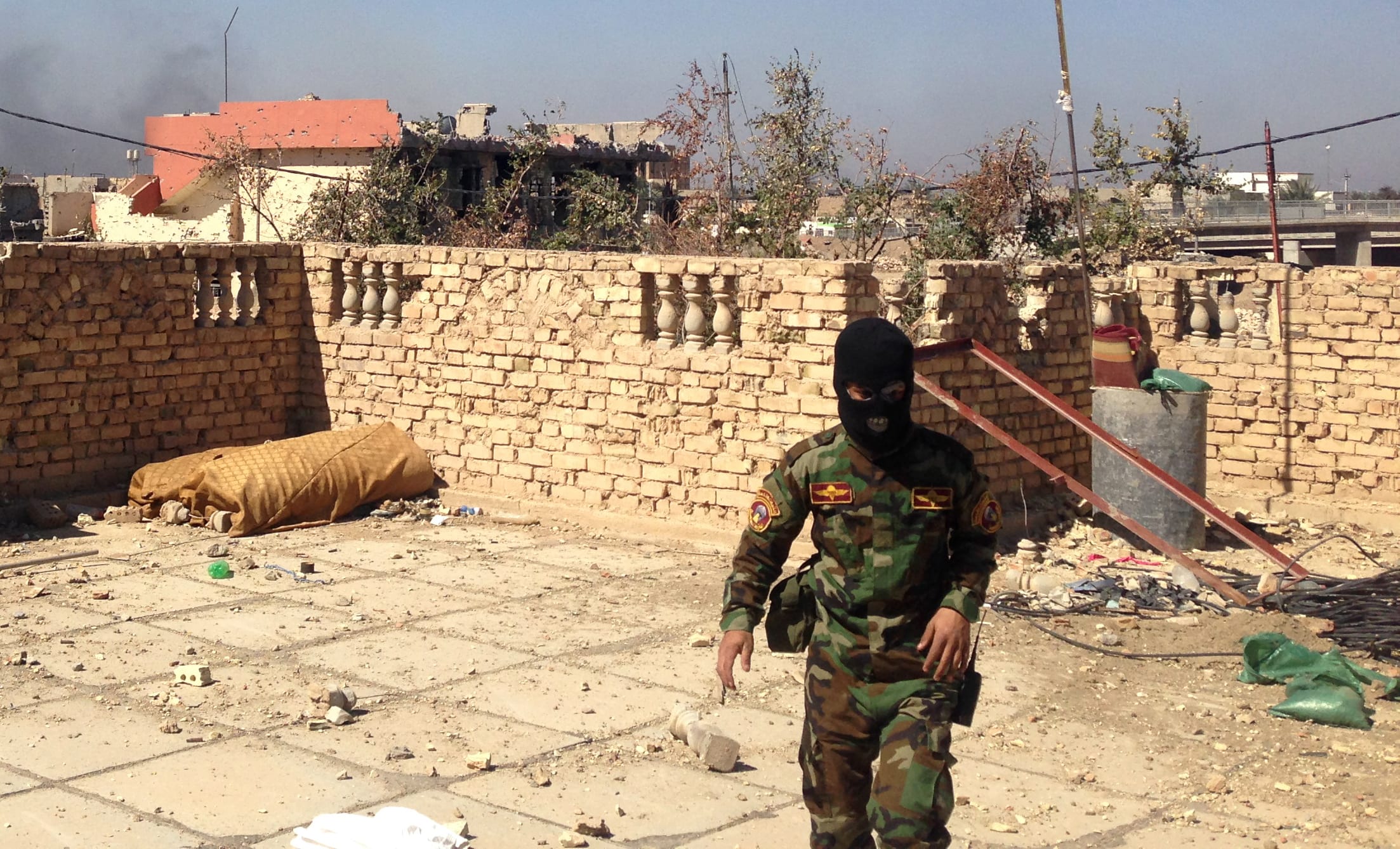 A member of the Iraqi police forces - face covered - during clashes with jihadists in Ramadi in March 2015.