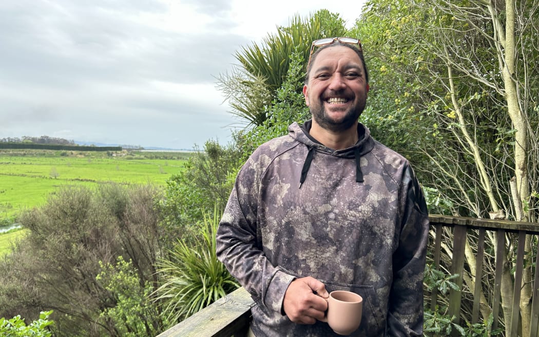 Portrait of a man standing in front of a farm.