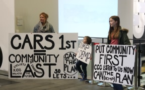Christchurch community members hold up signs in protest over the proposed Downstream Effects Management Plan.
