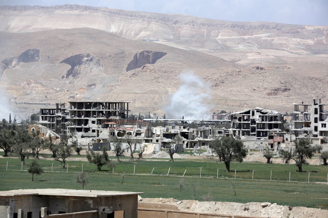Smoke billows as Syrian Army soldiers advance on April 8, 2018 in agricultural land on the eastern outskirts of Douma, as they continue their fierce offensive to retake the last opposition holdout in Eastern Ghouta.