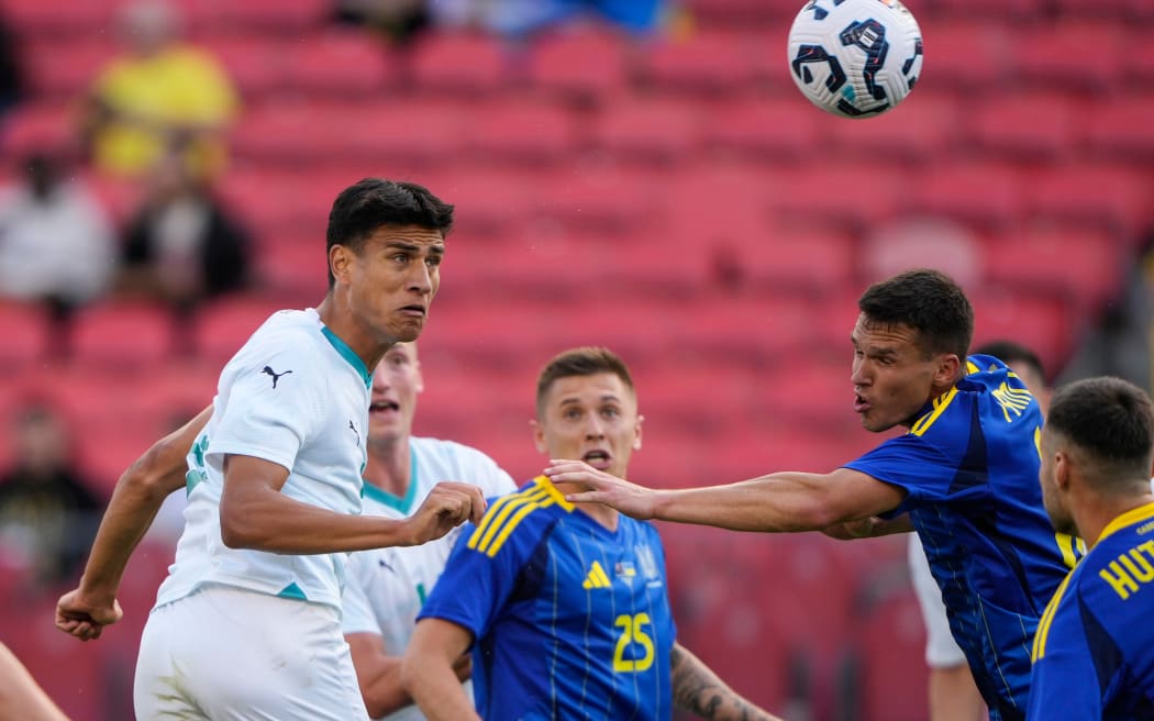 Marko Stamenic of New Zealand heads the ball at goal.
