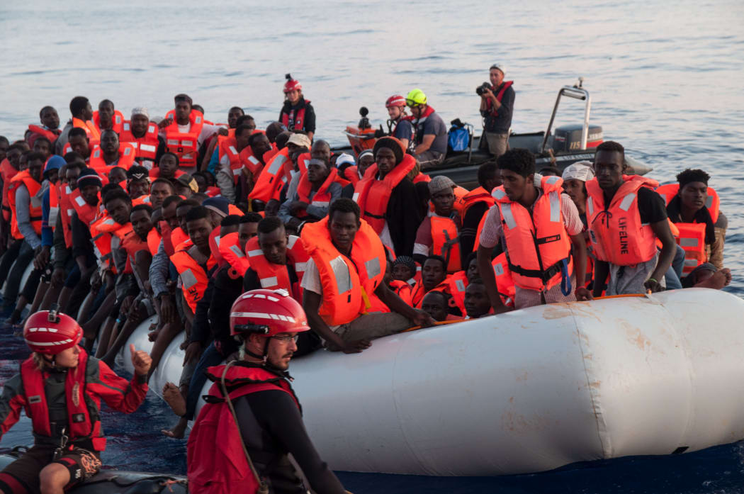 This handout picture obtained on June 22, 2018 from the German NGO 'Mission Lifeline' shows migrants on an inflatable boat beeing rescued before boarding the 'Lifeline' sea rescue boat at sea on June 21, 2018.