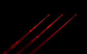 Red laser beams on black background
