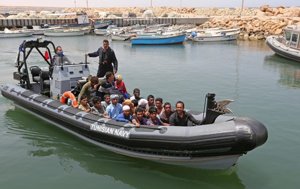 Migrants rescued by Tunisia's national guard during an attempted crossing of the Mediterranean by boat arrive at the port of el-Ketef in Ben Guerdane in southern Tunisia  on June 27, 2021. - Tunisia's defence ministry said  its navy had rescued 178 migrants