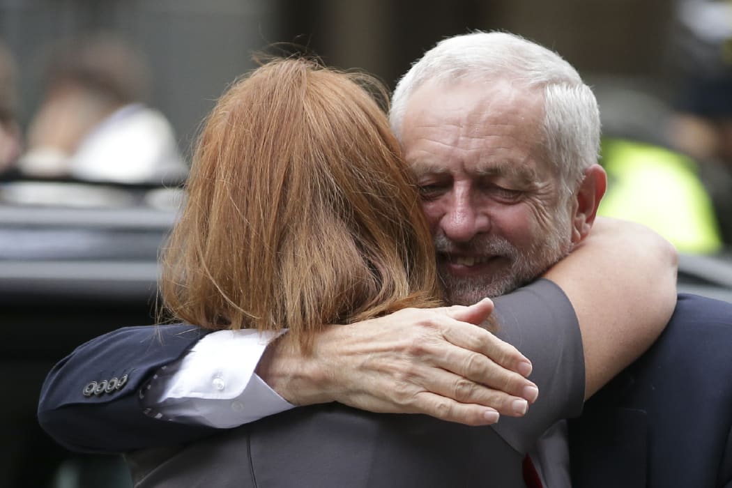 Britain's opposition Labour party Leader Jeremy Corbyn (R) embraces a member of his team Karie Murphy (L) as he arrives at Labour Party headquarters in central London on June 9, 2017