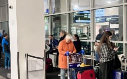Travellers queue at Auckland airport amis flight disruptions on 26 June 2026.