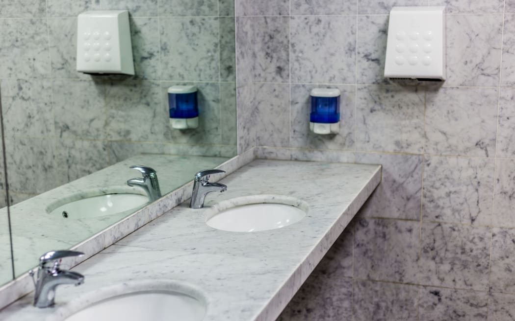public toilets with mirrors, marble top, soap dispenser and a fan to dry