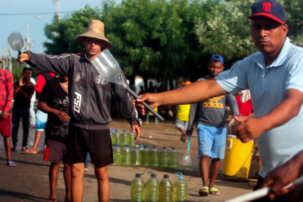 Men offer gasoline for sale on the streets of Maracaibo, Zulia State, Venezuela.