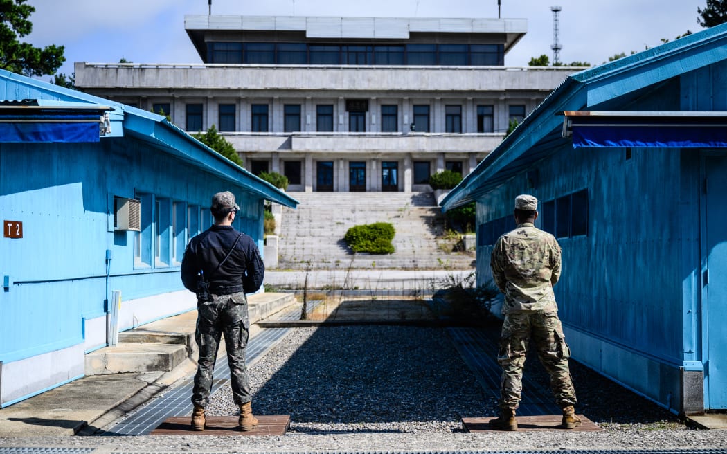 United Nations Command soldiers (right) and a South Korean soldier (left) stand guard before North Korea's Panmon Hall and the military demarcation line separating North and South Korea, at the Joint Security Area of the Demilitarized Zone on October 4, 2022.