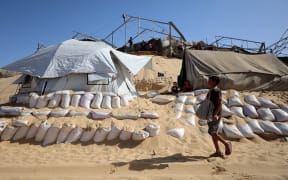 A child walks at a camp for displaced Palestinians set up near the beach in Khan Yunis in the southern Gaza Strip, on October 2, 2025, amid the ongoing conflict between Israel and the Palestinian militant group Hamas. (Photo by Omar AL-QATTAA / AFP)