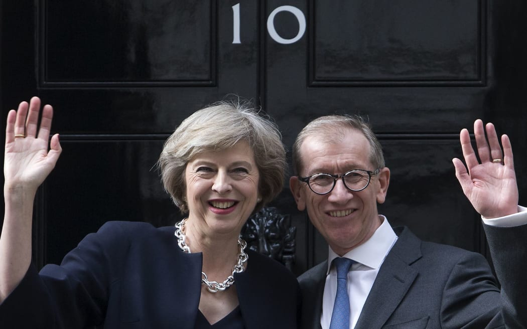 Britain's new Prime Minister Theresa May (L) and her husband Philip John (R) wave outside 10 Downing Street in central London on July 13, 2016 on the day she takes office following the formal resignation of David Cameron.
