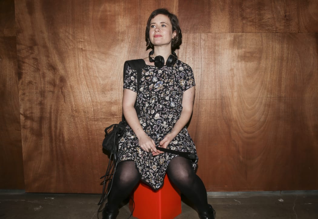 A portrait of Bang! producer and presenter Melody Thomas, wearing headphones and carrying a recording device.