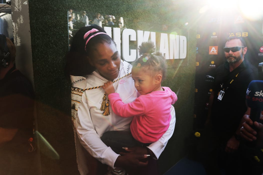 Serena Williams wrapped in a korowai with her daughter Alexis Olympia after her win against Jessica Pegula of the US during their women's singles final match at the Auckland Classic tennis tournament on January 12, 2020.