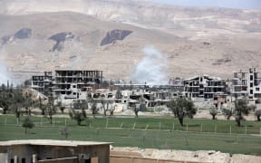 Smoke billows as Syrian Army soldiers advance on April 8, 2018 in agricultural land on the eastern outskirts of Douma, as they continue their fierce offensive to retake the last opposition holdout in Eastern Ghouta.