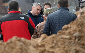 Austrian Chancellor Karl Nehammer (c) visits the site of a mass grave in the Ukrainian town of Bucha, near Kyiv on 9 April 2022.