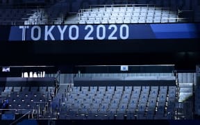 A spotlight highlights empty seats in the stadium ahead of the women's 3m springboard diving final event during the Tokyo 2020 Olympic Games at the Tokyo Aquatics Centre in Tokyo on August 1, 2021. (Photo by Attila KISBENEDEK / AFP)
