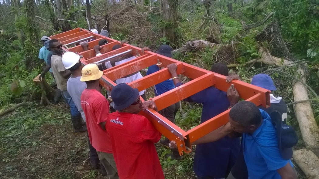 Villagers with the portable sawmill being used to mill timber for the post cyclone rebuild on Koro, Fiji