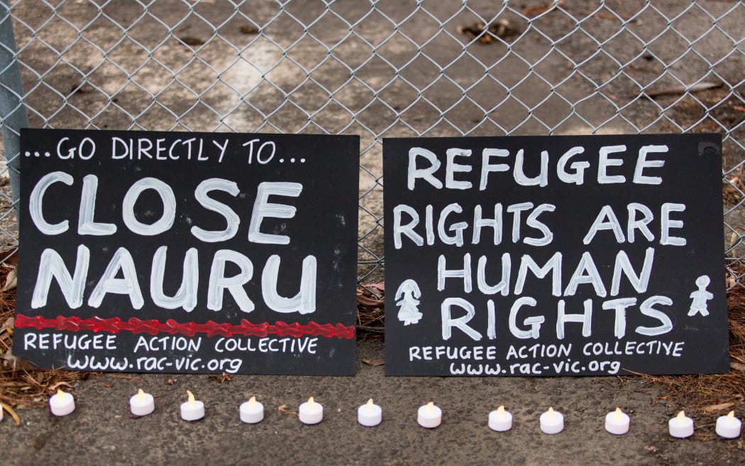 Two banners and candles at the gates of a refugee detention centre during a candlelight vigil. Asanka Brendon Ratnayake / Anadolu Agency