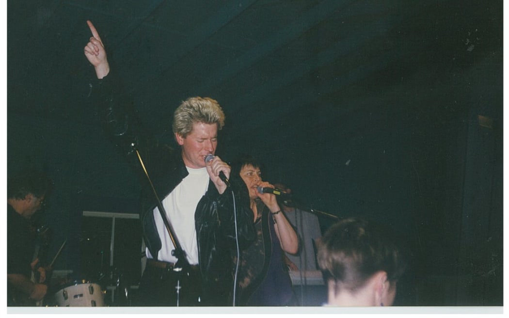 Bryan with dyed blonde hair acting out rockstar fantasy at the RNZ Xmas party, 1996.