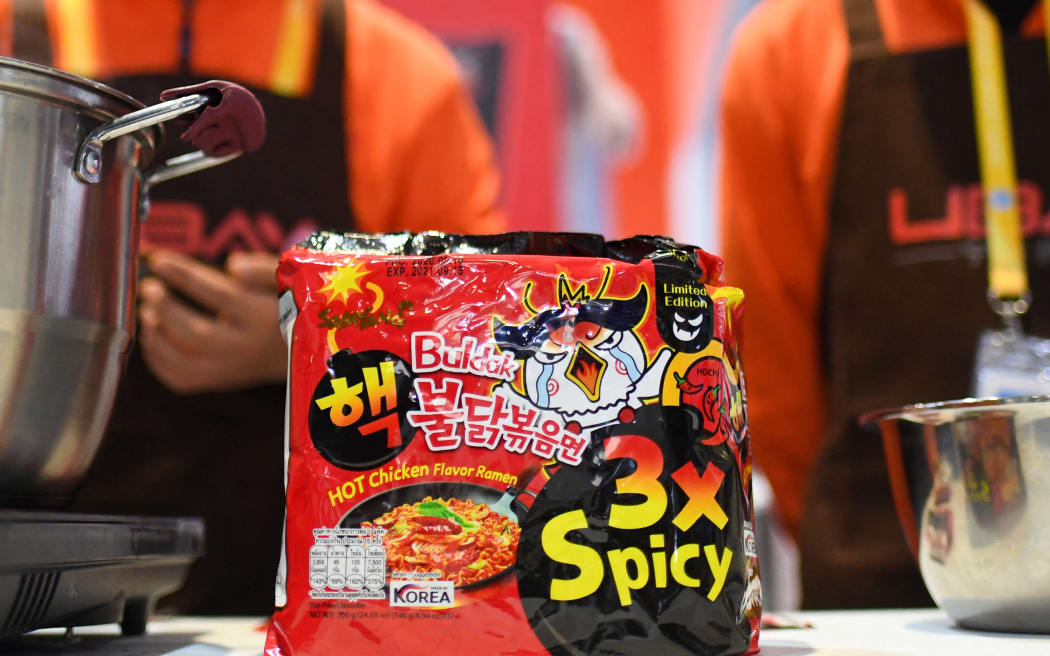 (201105) -- SHANGHAI, Nov. 5, 2020 (Xinhua) -- A staff member cooks turkey noodles at the booth of Samyang Foods Co., Ltd. at the Food and Agricultural Products exhibition area during the third China International Import Expo (CIIE) in Shanghai, east China, Nov. 5, 2020. Various foods from around the world are showcased at the Food and Agricultural Products exhibition area during the third CIIE in Shanghai. (Xinhua/Chen Yehua) (Photo by Chen Yehua / XINHUA / Xinhua via AFP)