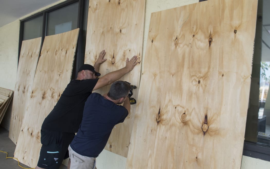 Workers put plywood over the windows at a Publix Supermarket in preparation for Hurricane Irma in Miami, Florida.