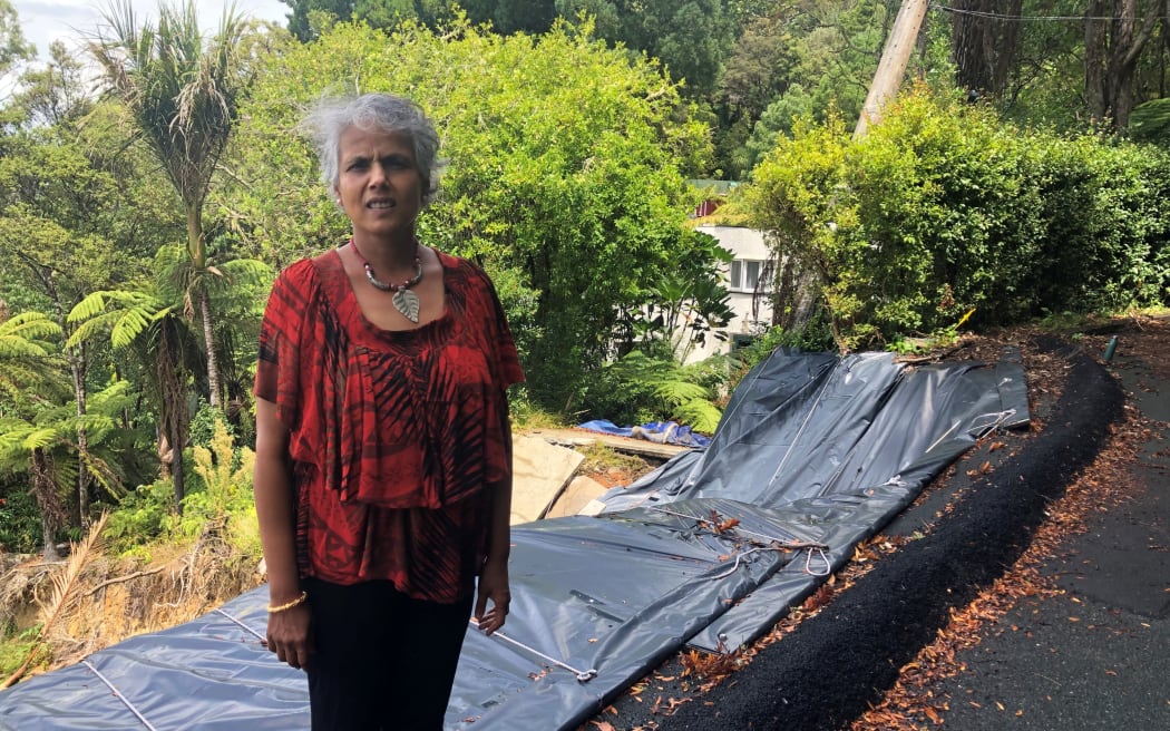 Paturoa road resident Sandy in front of the gaping hole that was once her driveway.