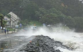 Big swells crash onto State Highway 11 in Paihia.