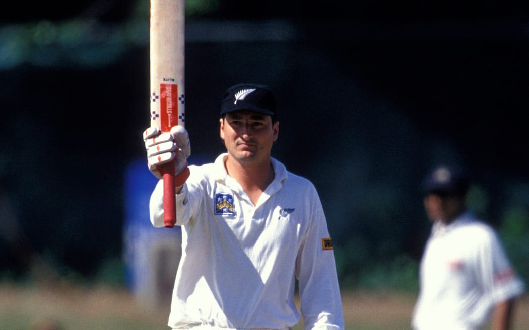 Batsman (and later captain) Ken Rutherford holds his bat up to acknowledge the crowd.