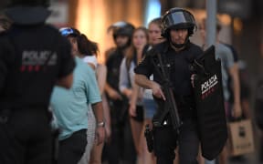 Spanish policemen stand guard in a cordoned off area after a van ploughed into the crowd, killing 13 persons and injuring over 50 on the Rambla in Barcelona on August 17, 2017.