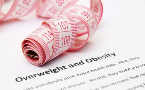 Measuring tape and leaflet on obesity.