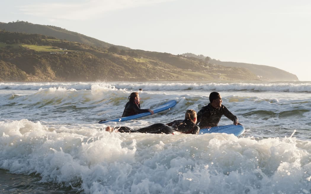 Surfing at Raglan Beach, Waikato.