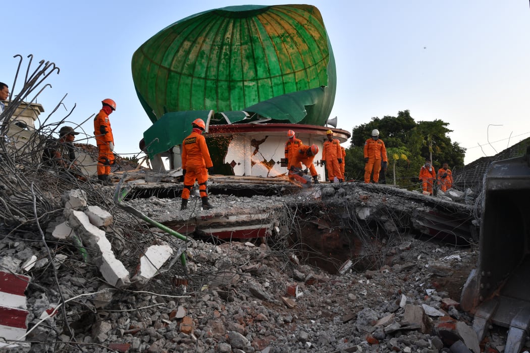 Indonesian search and rescue personnel work on a collapsed mosque in Pemenang.
