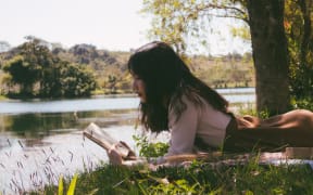 Stock image of woman reading outdoors
