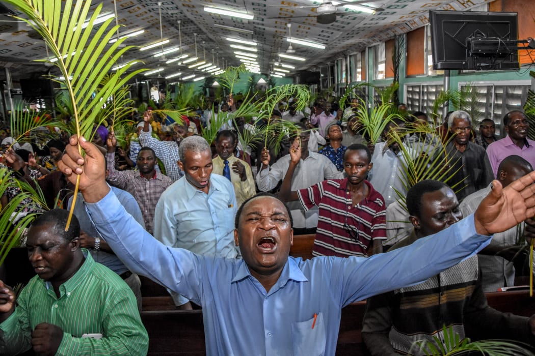 Believers pray without taking social distancing during a Palm Sunday mass at the Full Gospel Bible Fellowship Church in Dar es Salaam, Tanzania, on April 5, 2020