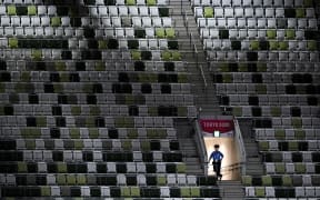 A police officer is seen in the empty stands ahead of the opening ceremony of the Tokyo 2020 Olympic Games.