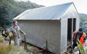 A 1700 kilogram hut, in danger of sliding into mountain bush, has been airlifted from from an active slip to stable ground in Mount Richmond Forest Park in Marlborough.