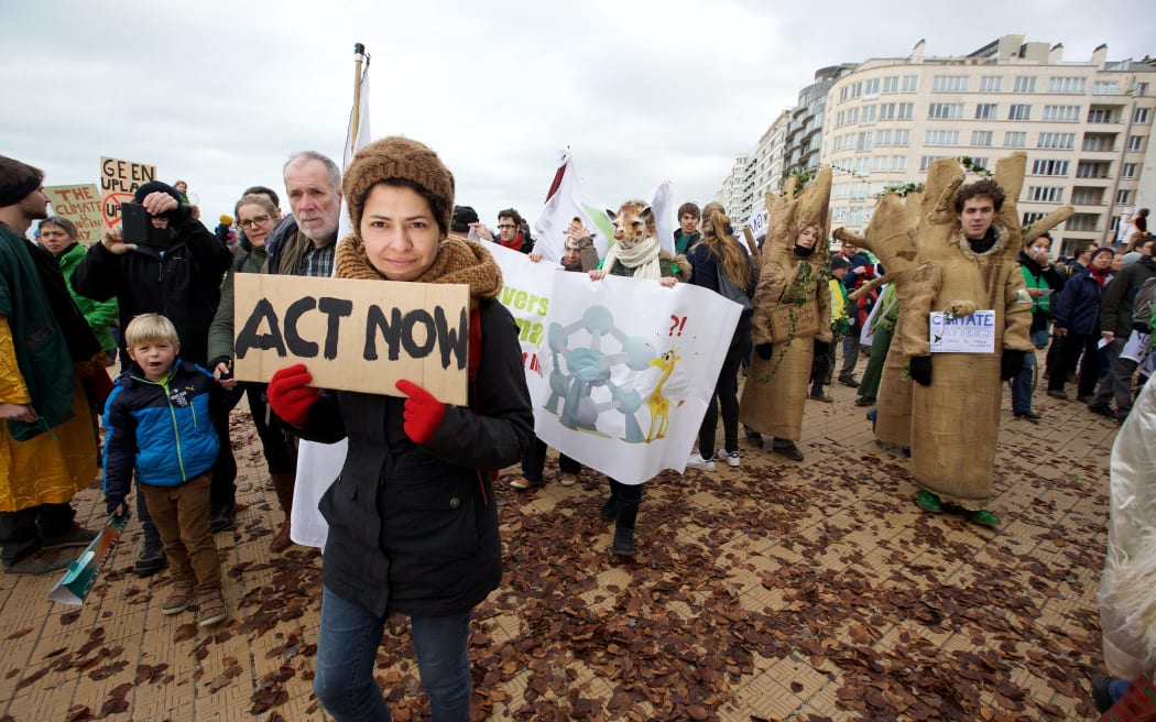 A woman holds up a sign as demonstrators gather for the 'Climate March' protest, during the COP21 United Nations Conference on Climate Change.