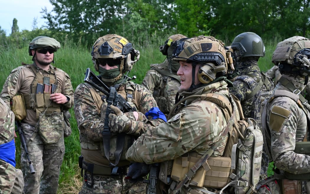 Fighters of the Russian Volunteer Corps attend a presentation for the media in northern Ukraine, not far from the Russian border, on May 24, 2023, amid Russian military invasion on Ukraine. Russian nationals fighting on Ukraine's side on May 24 hailed as a "success" a brazen mission to send groups of volunteers across the border into southern Russia and back. Russia on May 23 said it deployed jets and artillery to fight off armed attackers who crossed into the southern region of Belgorod from Ukraine, exposing weaknesses on Moscow's frontier. (Photo by SERGEY BOBOK / AFP)