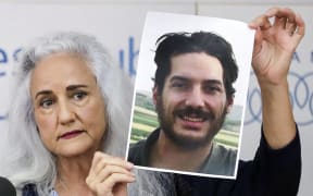 Debra Tice, mother of US journalist Austin Tice who was kidnapped in Syria five years prior, holds a dated portrait of him during a press conference in the Lebanese capital Beirut on July 20, 2017. (Photo by JOSEPH EID / AFP)