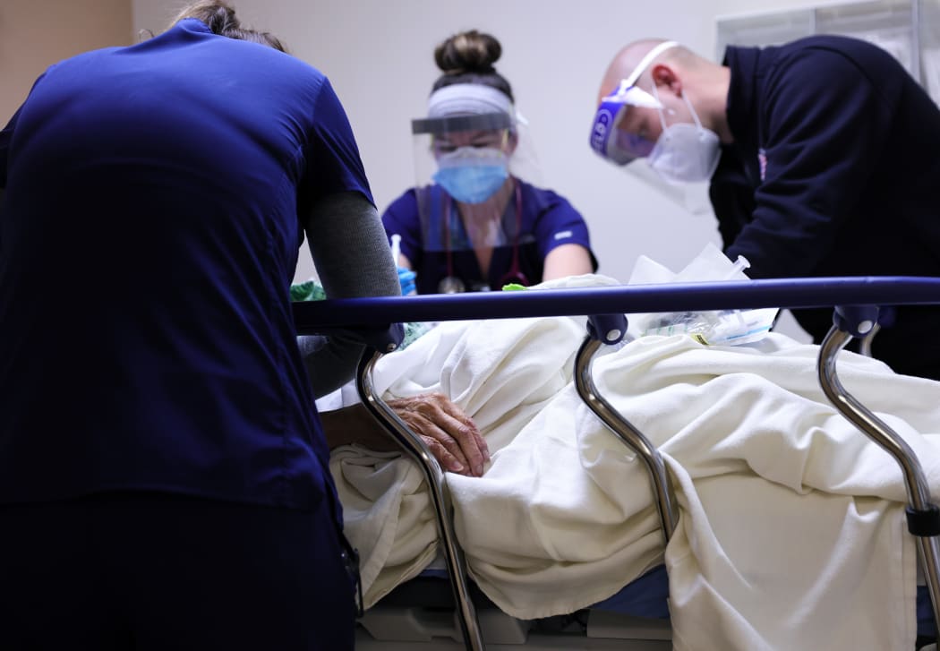 Clinicians care for a Covid-19 patient in a California hospital's isolation area