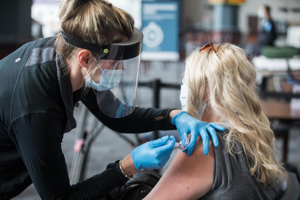 FOXBOROUGH, MA - JANUARY 15: A woman receives the COVID-19 vaccine at Gillette Stadium on January 15, 2021 in Foxborough, Massachusetts.