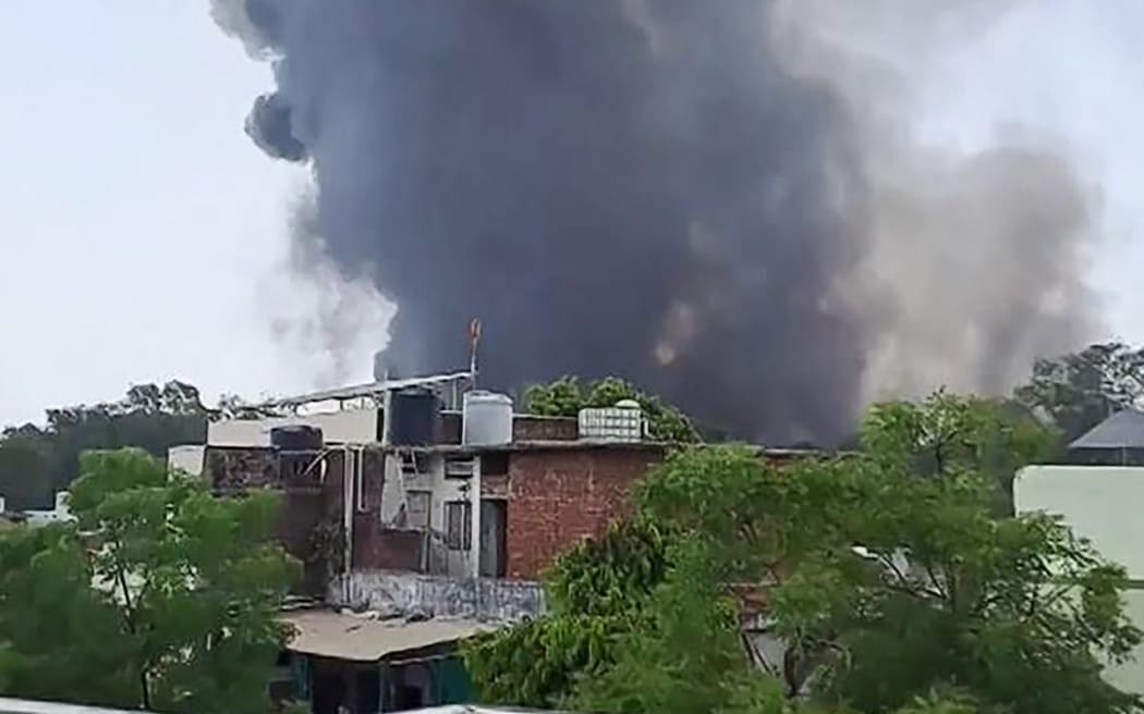 This frame grab from a video by @ashlovetea on June 12, 2025 made available on the Eurovision Social Newswire (ESN) platform via AFPTV shows a plume of smoke rising after Air India flight 171 crashed near the airport in Ahmedabad. The London-bound passenger plane crashed on June 12 in India's western city of Ahmedabad with 242 on board, aviation officials said in what the airline called a "tragic accident". (Photo by @ashlovetea / various sources / AFP) / NO USE AFTER JUNE 24, 2025 17:00:00 GMT - NO USE AFTER JUNE 24, 2025 17:00:00 GMT - -----EDITORS NOTE --- RESTRICTED TO EDITORIAL USE - MANDATORY CREDIT "AFP PHOTO /@ASHLOVETEA/ESN VIA AFPTV  " - NO MARKETING - NO ADVERTISING CAMPAIGNS - DISTRIBUTED AS A SERVICE TO CLIENTS - NO ARCHIVES /