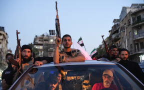 Syrian security forces ride a vehicle during a demonstration against Israeli intervention in Syria, in Damascus on July 16, 2025. Fighting erupted on July 13 between Druze fighters and Bedouin tribes, sparking government intervention, and Israeli strikes in support of the Druze. (Photo by Rami al SAYED / AFP)
